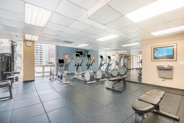 exercise room with a drop ceiling and floor to ceiling windows