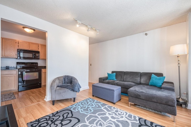 living room featuring a textured ceiling and light wood-type flooring