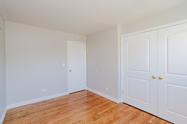 unfurnished bedroom with light hardwood / wood-style floors and a closet