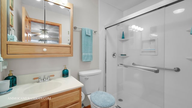 bathroom with vanity, ceiling fan, toilet, and an enclosed shower