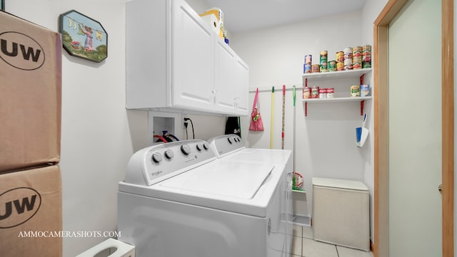 laundry room featuring cabinets, light tile patterned flooring, and washing machine and dryer