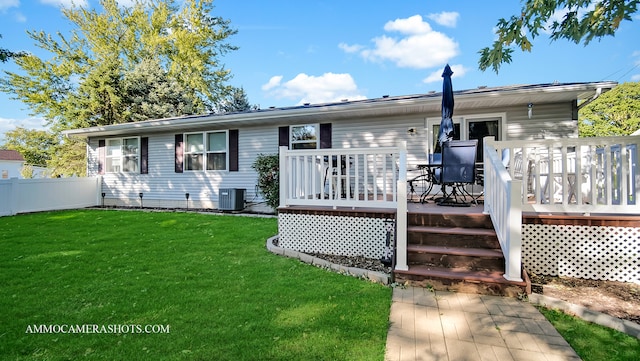 rear view of property with a wooden deck, a yard, and cooling unit