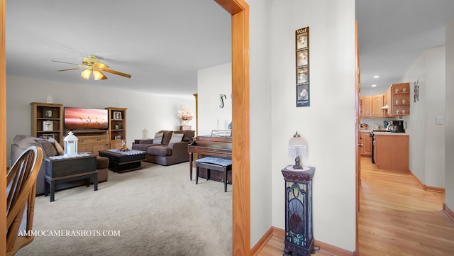 living room with ceiling fan and light hardwood / wood-style flooring