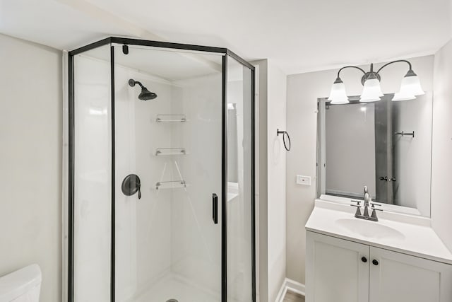 bathroom featuring vanity, toilet, and a shower with door