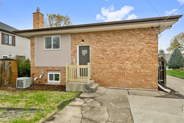 rear view of property with central AC unit