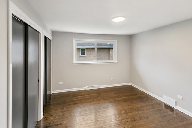 unfurnished bedroom with dark hardwood / wood-style floors