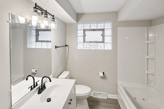 bathroom with toilet, vanity, and hardwood / wood-style floors