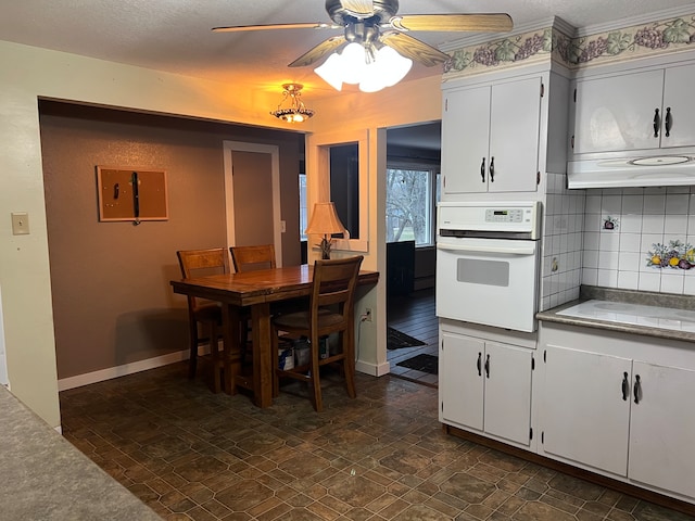 dining room with ceiling fan and dark tile patterned floors