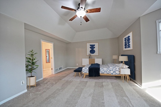 carpeted bedroom with ceiling fan, ensuite bathroom, and vaulted ceiling