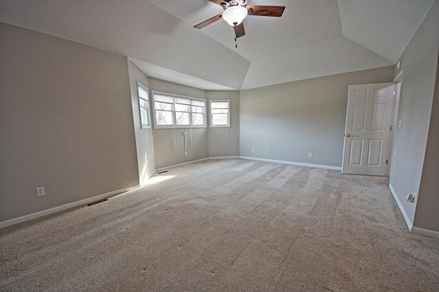 carpeted empty room with ceiling fan and vaulted ceiling