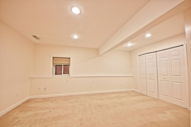 unfurnished bedroom with carpet flooring, beam ceiling, and a closet