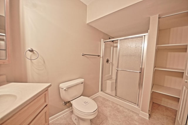 bathroom featuring toilet, tile patterned flooring, vanity, and walk in shower