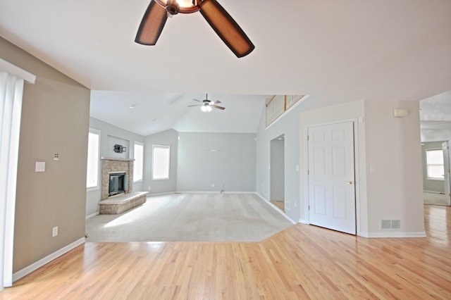 unfurnished living room with a wealth of natural light, ceiling fan, light hardwood / wood-style floors, and lofted ceiling