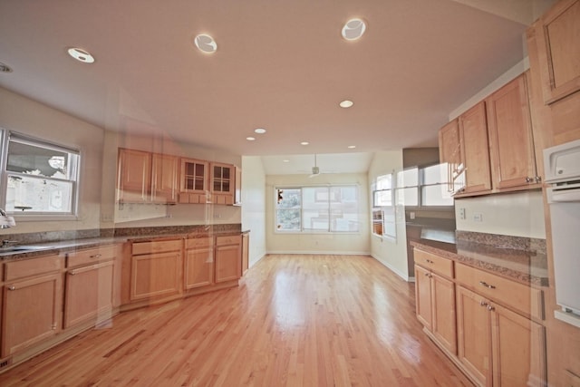 kitchen featuring light brown cabinets, light wood-type flooring, and ceiling fan