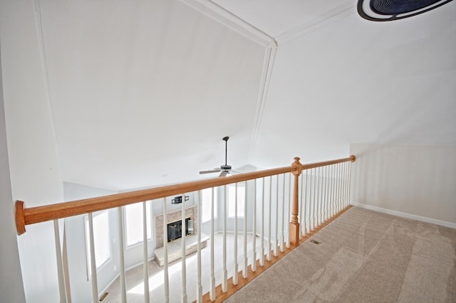 corridor featuring light carpet, lofted ceiling, and ornamental molding