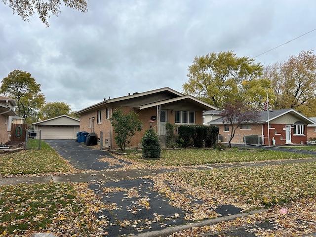 view of front facade with an outdoor structure, a front yard, central AC unit, and a garage