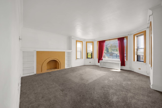 unfurnished living room with ornamental molding, dark colored carpet, built in shelves, and radiator