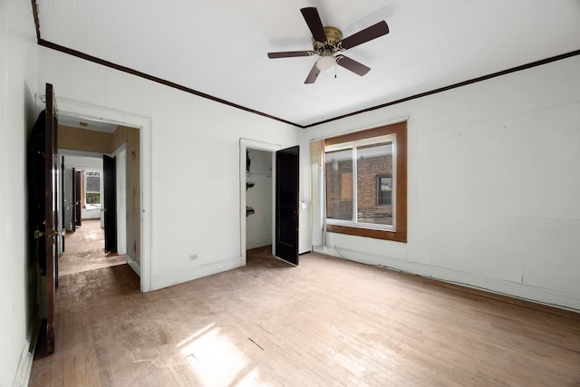 unfurnished bedroom featuring ornamental molding, a closet, hardwood / wood-style flooring, and ceiling fan