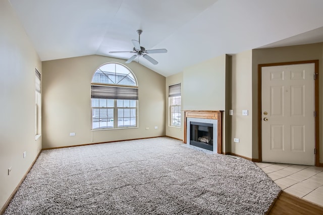 unfurnished living room with ceiling fan, light colored carpet, and lofted ceiling