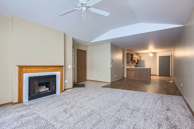 unfurnished living room with light hardwood / wood-style flooring, vaulted ceiling, and ceiling fan