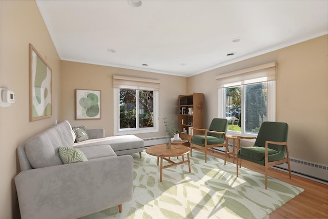 living room featuring baseboard heating, ornamental molding, and light wood-type flooring