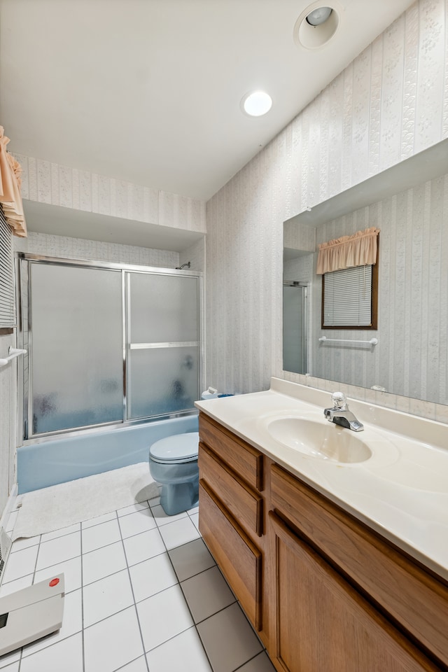 full bathroom with toilet, combined bath / shower with glass door, vanity, and tile patterned floors