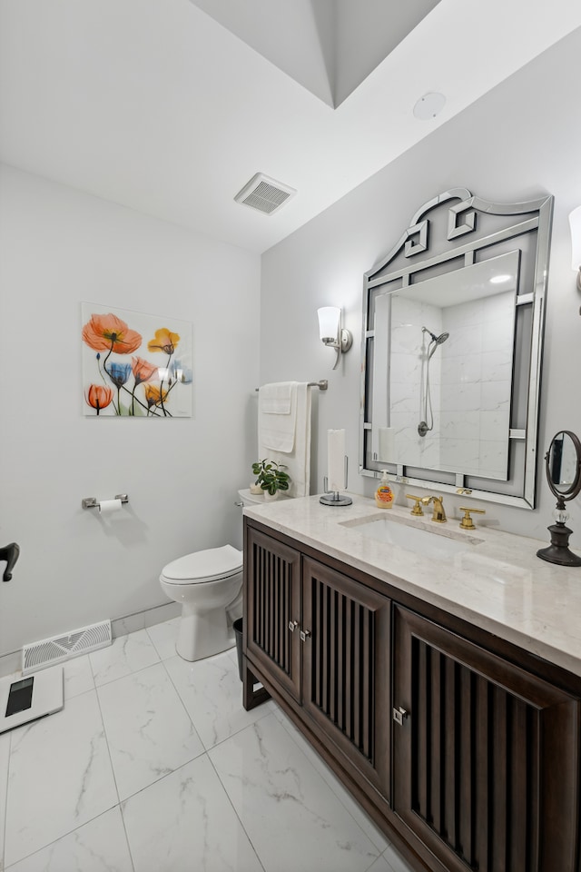 bathroom with vanity, toilet, and a tile shower