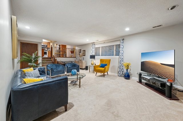 carpeted living room featuring a textured ceiling