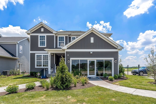 view of front of property with a front yard and central AC unit