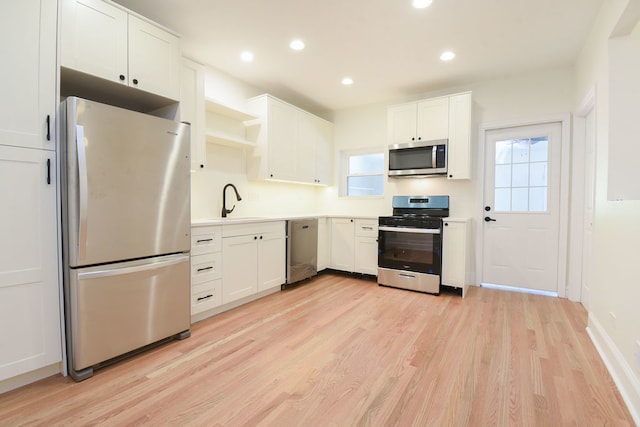 kitchen with white cabinetry, light hardwood / wood-style flooring, and appliances with stainless steel finishes