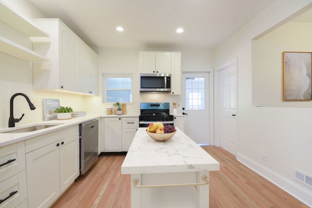 kitchen featuring light wood-type flooring, white cabinetry, and appliances with stainless steel finishes