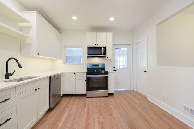 kitchen featuring white cabinets, light hardwood / wood-style floors, and stainless steel appliances