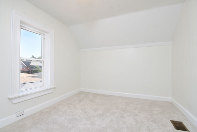 bonus room featuring light colored carpet and vaulted ceiling