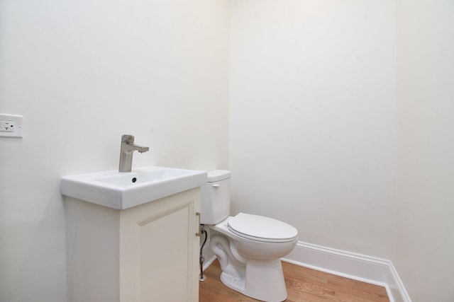 bathroom featuring vanity, hardwood / wood-style flooring, and toilet