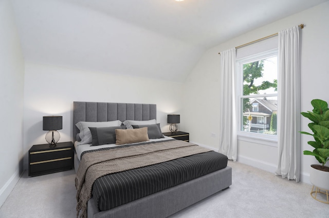 carpeted bedroom with lofted ceiling