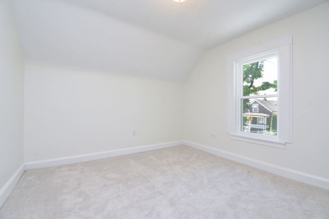 bonus room with light colored carpet and lofted ceiling