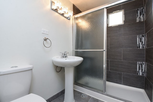 bathroom with an enclosed shower, toilet, and tile patterned floors