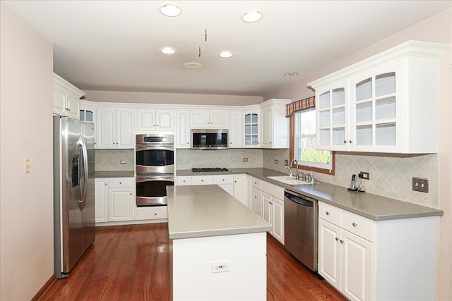 kitchen with white cabinetry, a center island, dark wood-type flooring, pendant lighting, and appliances with stainless steel finishes