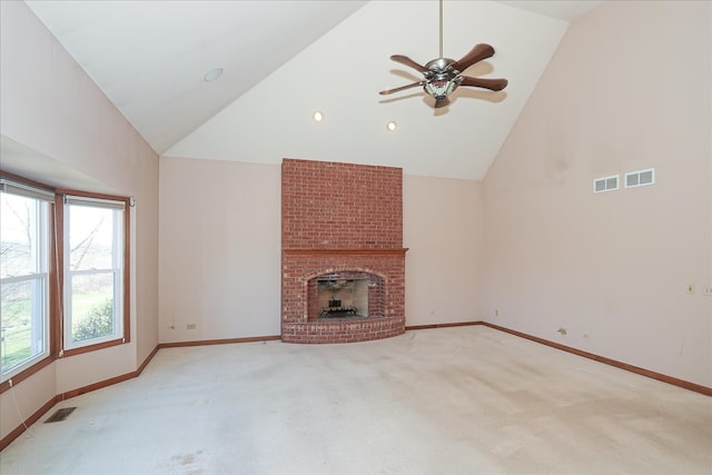 unfurnished living room featuring high vaulted ceiling, light colored carpet, a brick fireplace, and ceiling fan