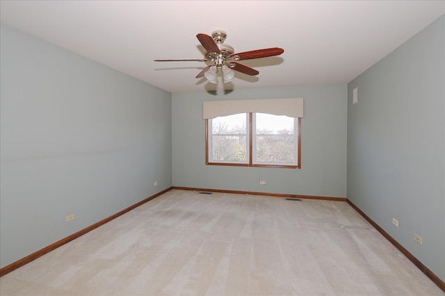 carpeted spare room featuring ceiling fan