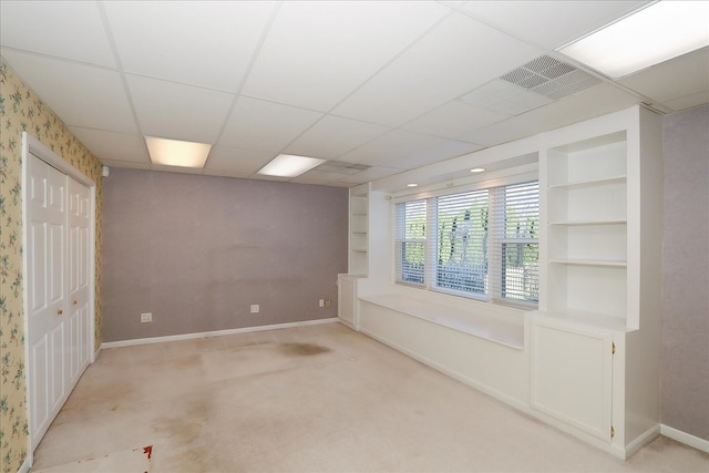 basement featuring carpet and a drop ceiling