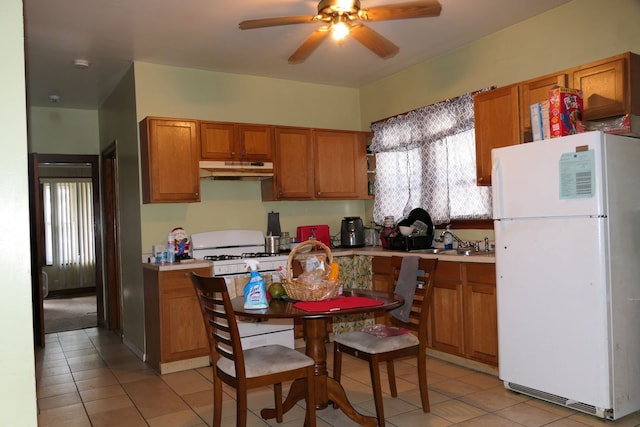 kitchen featuring a healthy amount of sunlight, light tile patterned flooring, ceiling fan, and white appliances