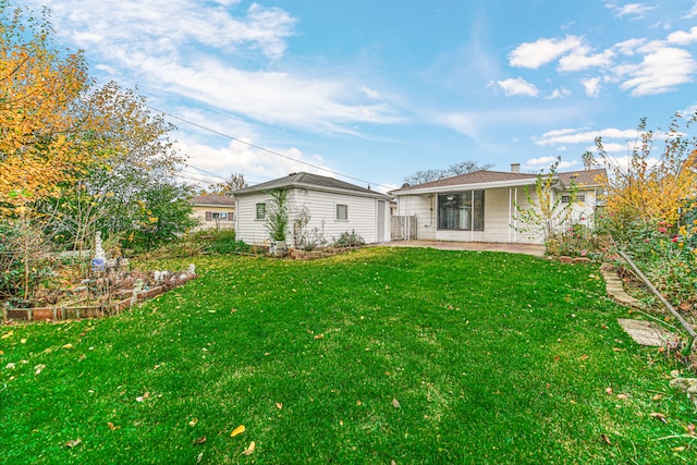 rear view of house featuring a yard and a patio