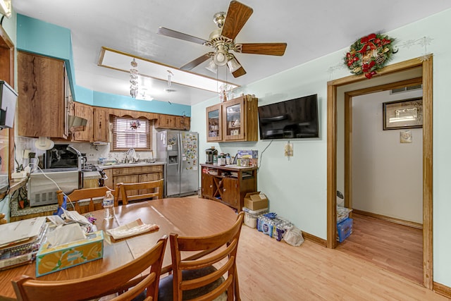 dining room with light wood-type flooring, sink, and ceiling fan