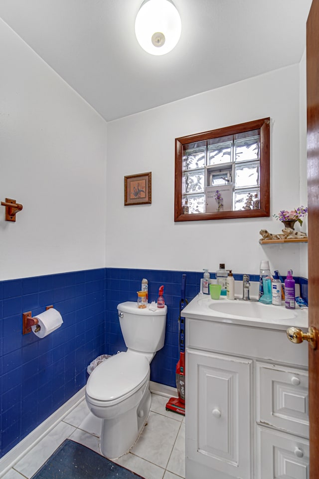 bathroom with tile walls, tile patterned flooring, vanity, and toilet