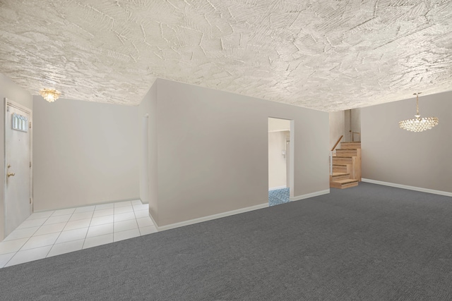 interior space with a textured ceiling, carpet flooring, and a notable chandelier