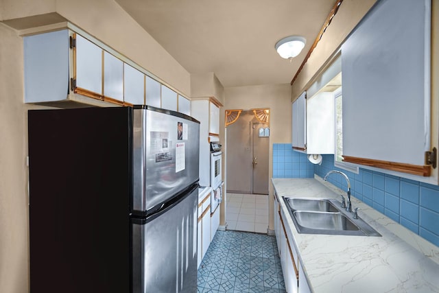 8916 S Eggleston Ave, Chicago, IL 60620 - kitchen featuring freestanding refrigerator, a sink, light countertops, backsplash, and oven