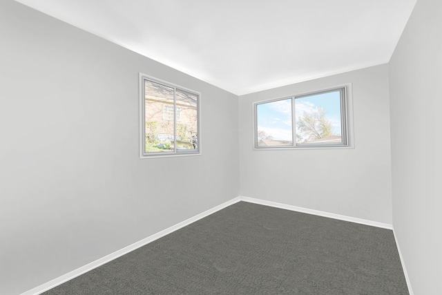 unfurnished room with dark colored carpet