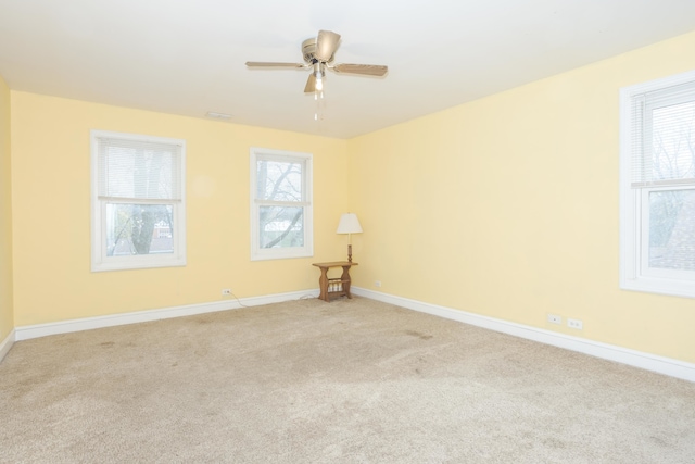 carpeted spare room featuring ceiling fan