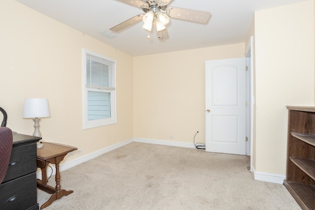 carpeted office space featuring ceiling fan